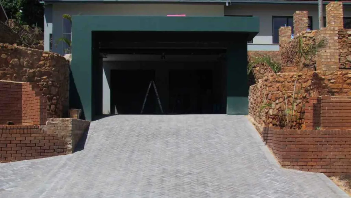 Driveway Paving Pretoria & Centurion 8 Charcoal paved driveway rising to a garage between stone-clad retaining walls in Wonderboom, Pretoria